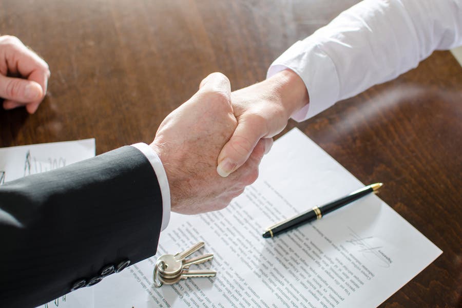 shaking hands over contract and house keys